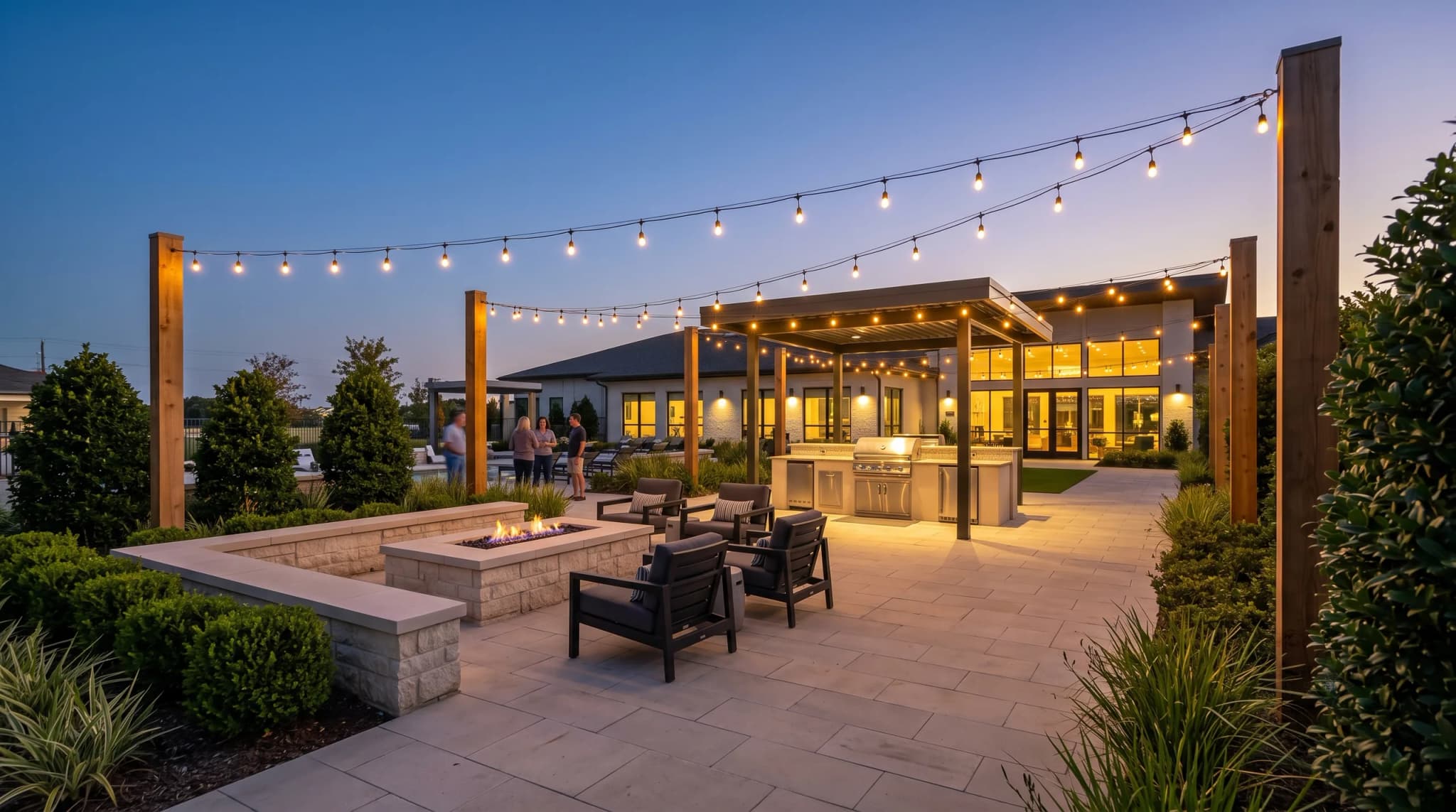A clubhouse terrace of café tables under string lights, with residents seated at mid-distance, faces indistinct.